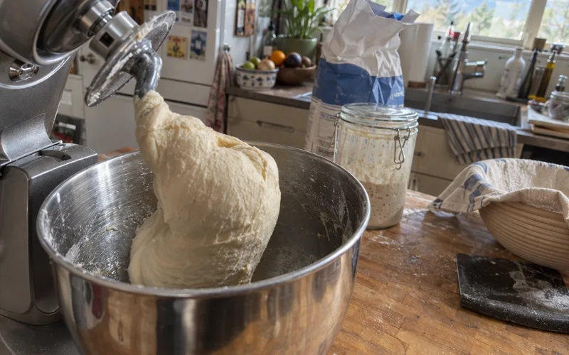 Smooth sourdough discard cinnamon roll dough pulling away from the sides of a stand mixer bowl