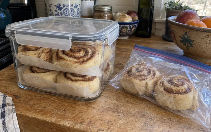 Leftover cinnamon rolls stored in an airtight container with parchment between layers